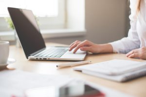 woman in white working on laptop