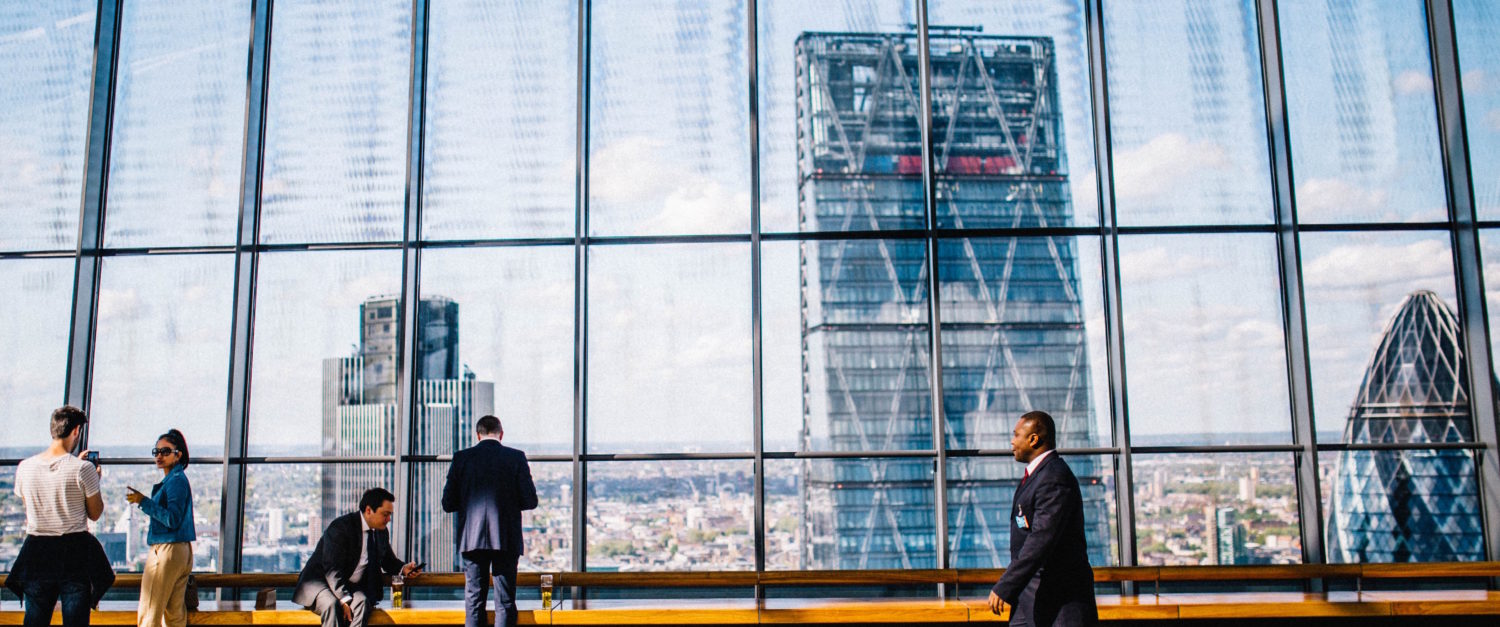 corporate mentoring - group of people on break looking outside at skyscrapers