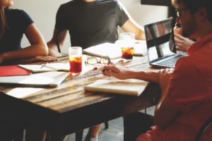 group of coworkers working on wooden table