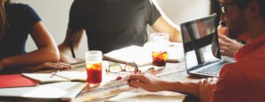 group of coworkers working on wooden table