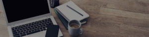 laptop and notebook on wooden desk