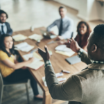 man giving speech to coworkers - mentoring communication business webinars