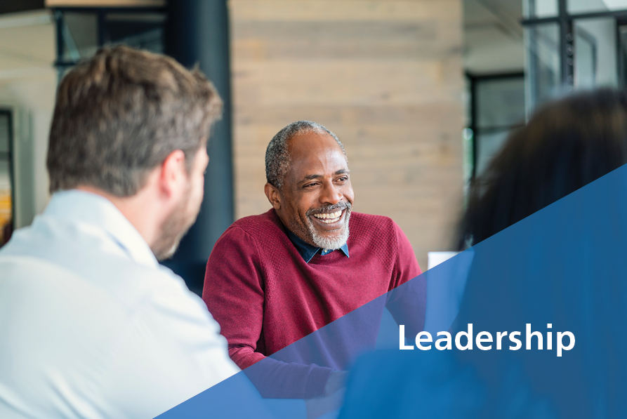 Happy mature male manager sitting with colleagues - Leadership - TED Talks