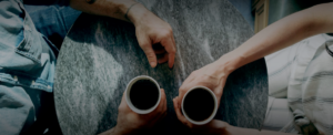 two people holding coffee mugs