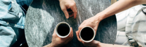 two people holding coffee mugs