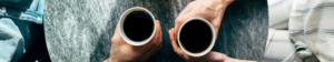 two people holding coffee mugs