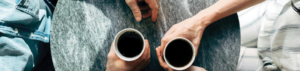 two people holding coffee mugs