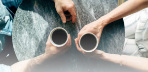 two people holding coffee mugs