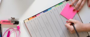 female' hand writing on post-it note - scheduling business mentor event
