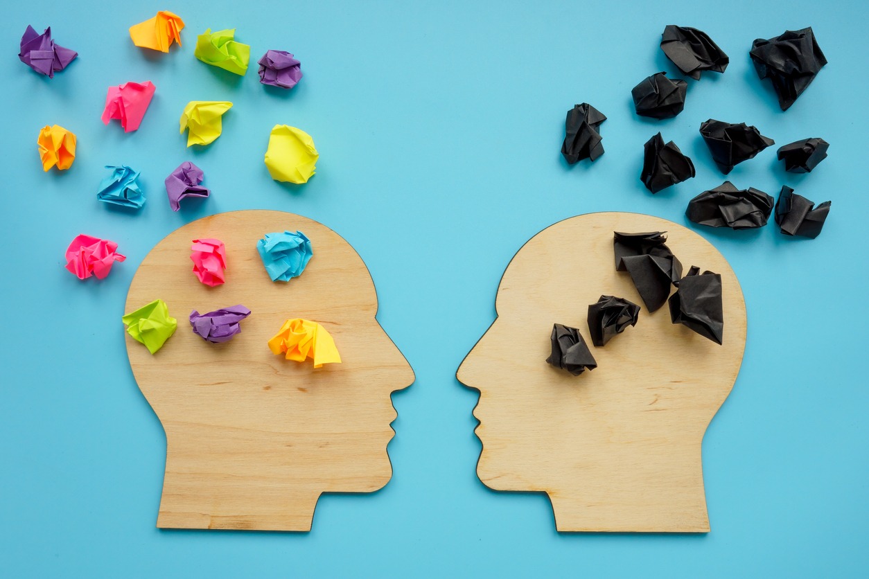 Positive Mental Attitude. Negative and positive thinking concept. Head shapes with color paper balls.