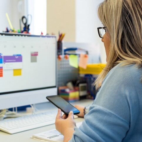 Female child therapist in an office during a phone call, using online calendar to schedule patients appointments. Calendar Planner Organization Management Concept.