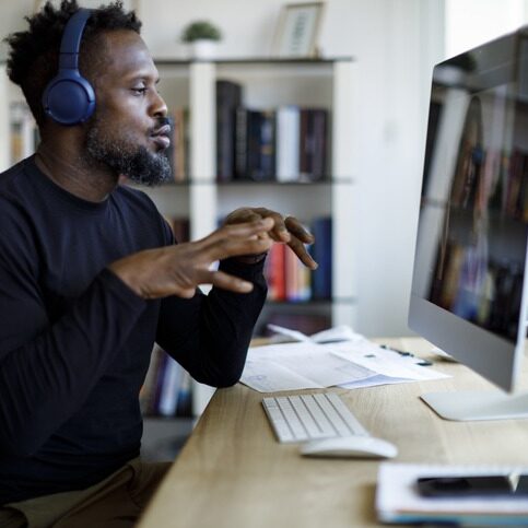 Man with headphones having video call at home office